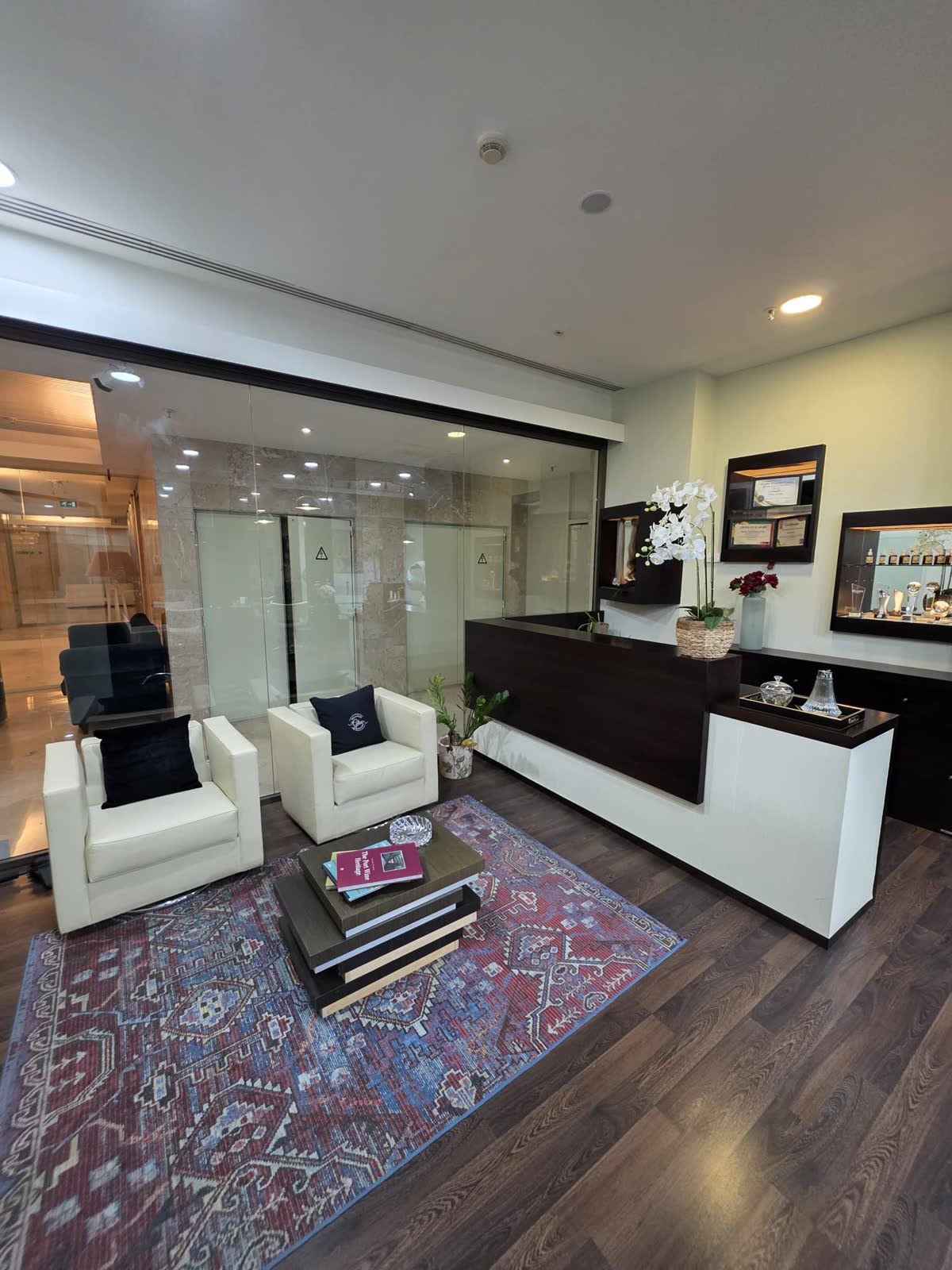 Receção do Max Freire Hair Studio com poltronas e balcão em madeira escura